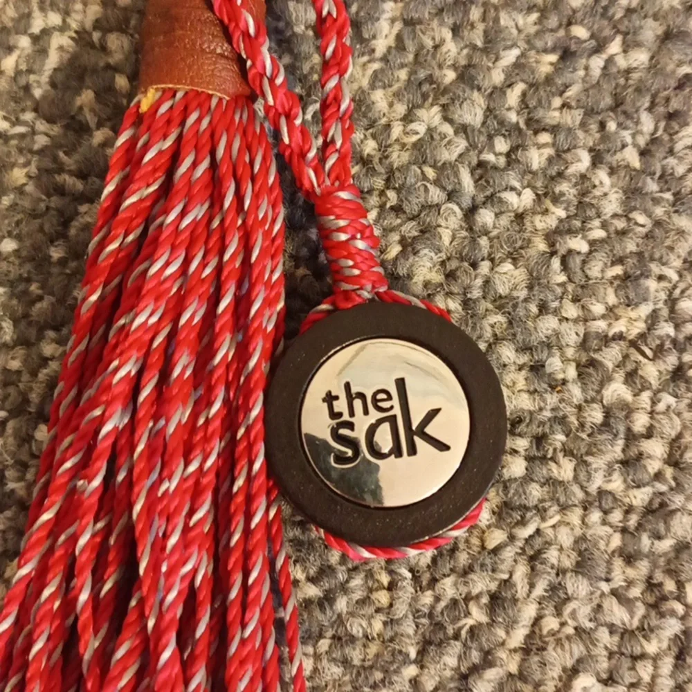 The Sak red and brown leather keychain the Sak emblem